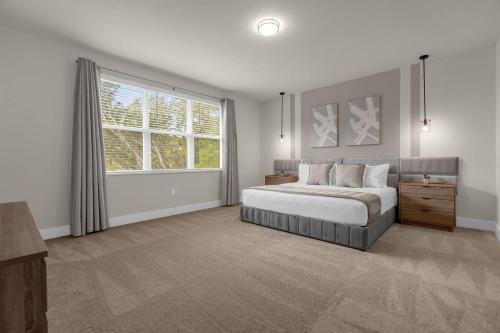 a bedroom with a large bed and a window at Upstay - Townhouse with Private Pool and Foosball in Orlando