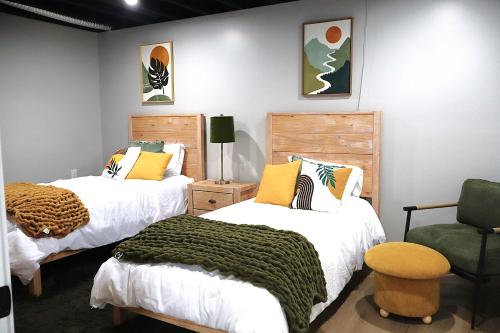 a bedroom with two beds and a green chair at Buck Run - a secluded cabin in Rockbridge, OH in Rockbridge