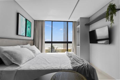 a bedroom with a bed and a large window at Alta Garden Housi João Pessoa by Carpediem in João Pessoa