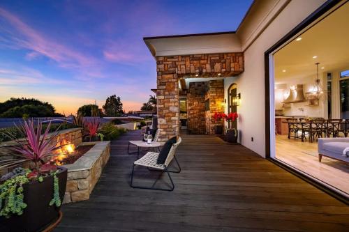 a backyard deck with a fireplace and a patio at 4BR Luxury Del Mar Beach House with Ocean Views in San Diego