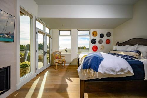 a bedroom with a bed and a fireplace and windows at 4BR Luxury Del Mar Beach House with Ocean Views in San Diego