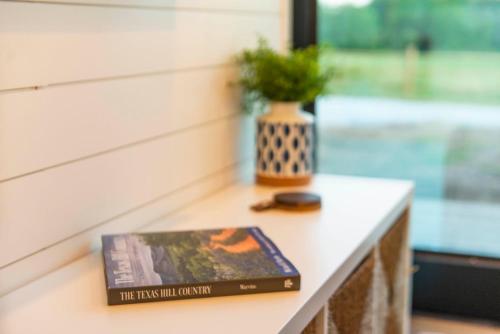 a book sitting on a table with a vase at The Bluebonnet-Tiny Container Home Country Setting 12 min to Downtown in Bellmead