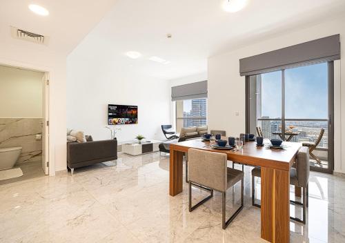 a dining room with a table and a living room at Luxury Beachfront 2Bd Apt, Shams, JBR in Dubai