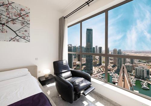 迪拜Luxury Beachfront 2Bd Apt, Shams, JBR的带椅子和大窗户的卧室