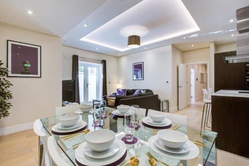 a kitchen and living room with a glass table at Newlands Pepe by Artsy in London