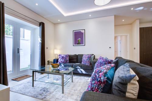 a living room with a couch and a table at Newlands Pepe by Artsy in London