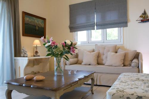 a living room with a couch and a table with flowers at Amalia Apartments in Exanthia