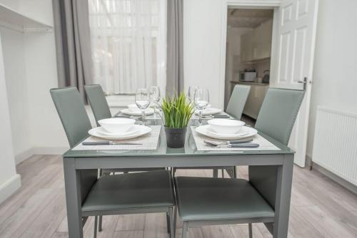 ノーサンプトンにあるBlissful Stays 3 Bedroom Homeのダイニングルームテーブル(椅子付)、テーブル(ワイングラス付)