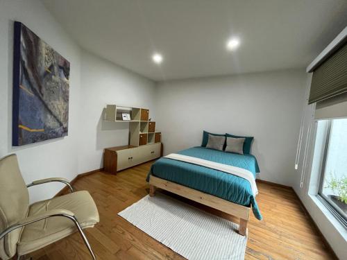 a bedroom with a bed and a chair and a window at La Casa del Agua Puebla in Acatepec
