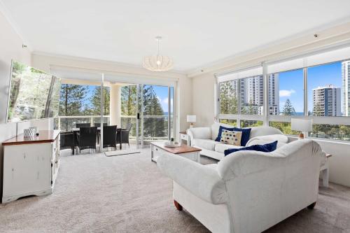 a living room with white furniture and large windows at Oscar on Main 2B - Heart of Main Beach Ocean Views - Hosted by Coastal Letting Co. in Gold Coast