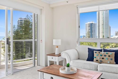 a living room with a couch and large windows at Oscar on Main 2B - Heart of Main Beach Ocean Views - Hosted by Coastal Letting Co. in Gold Coast