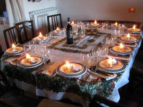 una mesa con velas, platos y vasos. en Agriturismo Santa Maria, en Torrita di Siena