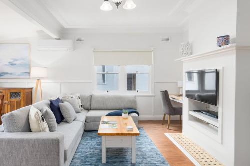 a living room with a couch and a table at Bally Escape - Cottage Serenity in a Scenic Village in Balgownie