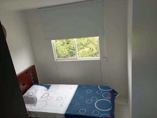 a small bedroom with a bed and a window at Apartamento moderno en Cali in Cali