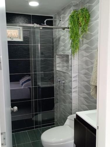 a bathroom with a toilet and a glass shower at Apartamento moderno en Cali in Cali
