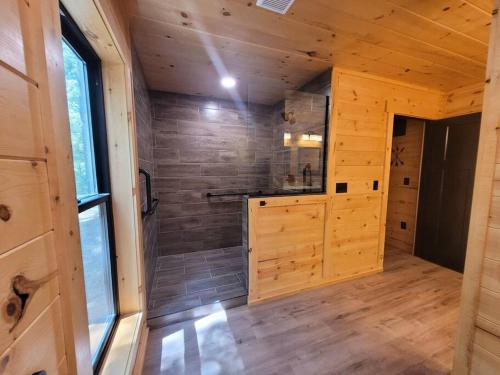 a large bathroom with a shower in a wooden house at The Saige - Hot Tub, Fire Pit, and huge entertainment area in Logan