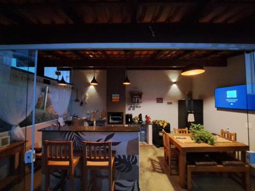 una stanza con tavolo, sedie e cucina di Aconchego do Pôr do Sol Sebollas a Inconfidência