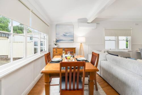 a dining room with a table and chairs and a couch at Bally Escape - Cottage Serenity in a Scenic Village in Balgownie