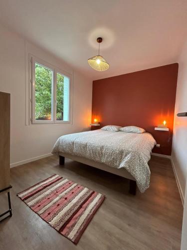 une chambre avec un lit et un mur rouge dans l'établissement Villa la Farigoule, à Carpentras