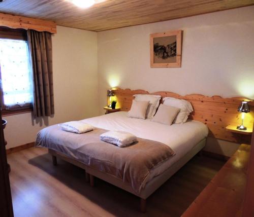 une chambre avec un lit avec deux oreillers dessus dans l'établissement Résidence Lou Baitandys - Plein centre, skis aux pieds, vue dégagée sur pistes MAE-0851, aux Gets