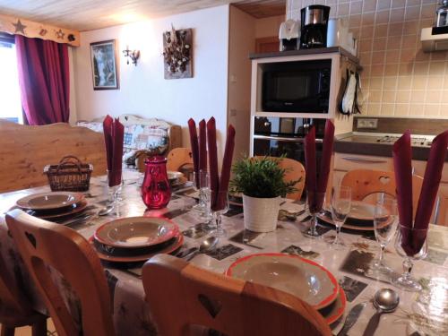 - une table à manger avec des assiettes et des verres à vin dans l'établissement Résidence Lou Baitandys - Plein centre, skis aux pieds, vue dégagée sur pistes MAE-0851, aux Gets