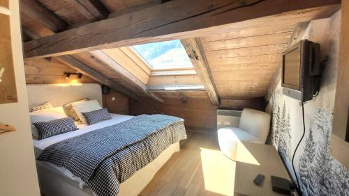 une chambre avec un lit et une télévision dans une pièce dans l'établissement Résidence Le Lion D'or A - Appartement confortable, sous toit, accès facile aux commerces MAE-0871, aux Gets