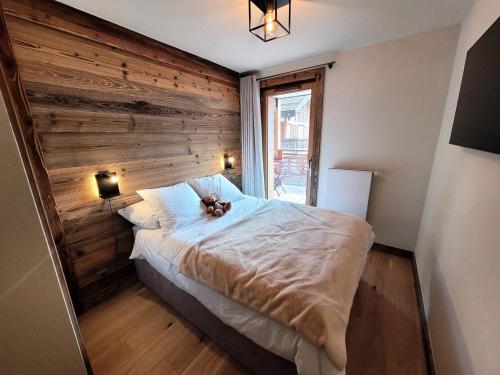 une chambre avec un lit avec un ours en peluche dessus dans l'établissement Résidence Le Stella - Appartement haut de gamme 6 personnes au centre MAE-1001, aux Gets