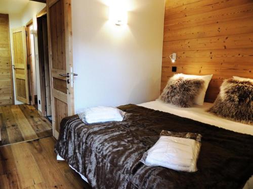 une chambre avec un lit et un mur en bois dans l'établissement Résidence Le Kilimandjaro - 3 Pièces + cabine à deux pas du centre village MAE-1041, aux Gets