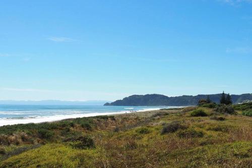 a beach with the ocean in the background at Paradise on the Sand in Whakatane