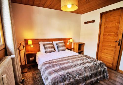 une chambre avec un grand lit avec une tête de lit en bois dans l'établissement Résidence Le Plein Sud - très bel appartement classé 4, rénové avec soin et bien équipé MAE-1011, aux Gets