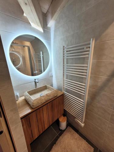 une salle de bain avec un lavabo et un miroir dans l'établissement Résidence Le Hameau Des Cornuts - Vivez un séjour de charme dans cet appartement sous toit MAE-1021, aux Gets