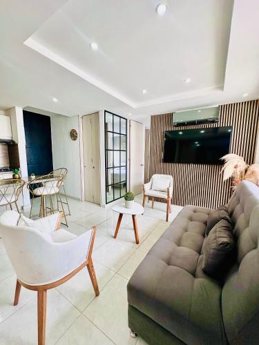 a living room with a couch and a television at Apartamento tranquilo y completo a 5 min de Girardot, cerca al Centro Comercial Peñaliza Mall in Ricaurte
