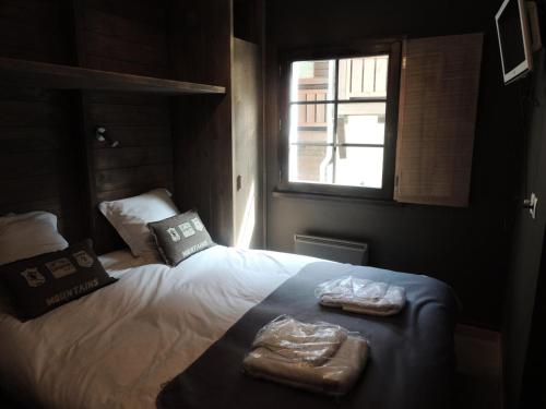 une chambre avec un lit avec deux serviettes dessus dans l'établissement Résidence Fermes Emiguy - T2 cabine de charme dans residence de prestige MAE-1141, aux Gets