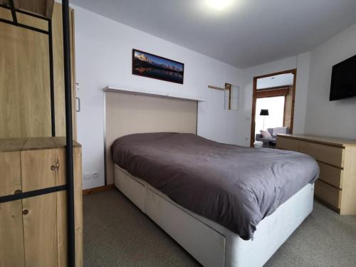 une chambre avec un lit et une télévision à écran plat dans l'établissement Résidence Chanteneige - Appartement lumineux et rénové MAE-1181, aux Gets