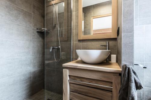 une salle de bain avec un lavabo et une douche en verre dans l'établissement Résidence Le Kilimandjaro - Appartement très cosy, 2 chambres en suite, proche commerces MAE-1201, aux Gets