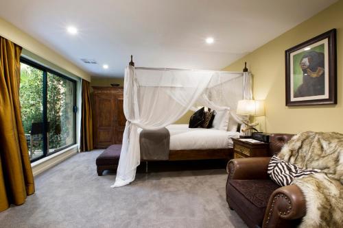 a bedroom with a canopy bed and a couch at Jamala Wildlife Lodge in Canberra