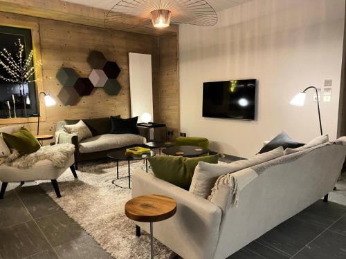 un salon avec deux canapés et une télévision dans l'établissement Chalet 1839 - Superbe appartement coeur de station, pied des pistes MAE-0901, aux Gets