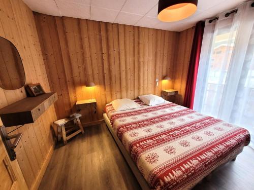 une chambre avec un lit dans une pièce aux murs en bois dans l'établissement Résidence Le Centre - Appartement au centre 6 personnes MAE-0961, aux Gets