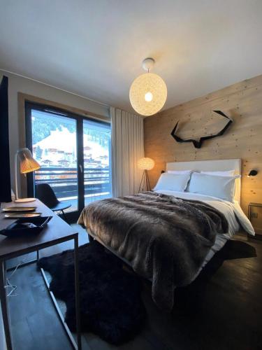 une chambre avec un lit, un bureau et une fenêtre dans l'établissement Chalet 1839 - Superbe appartement coeur de station, pied des pistes MAE-0901, aux Gets