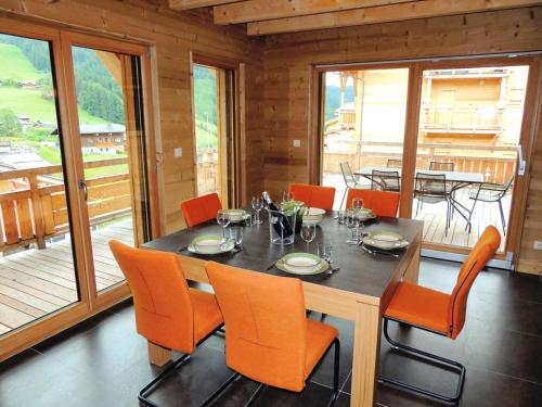 - une salle à manger avec une table et des chaises orange dans l'établissement Chalet Source Des Granges - Chalet Source des Granges - Calme et confort MAE-0991, aux Gets