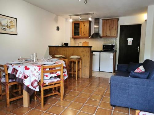 une cuisine et un salon avec une table et des chaises dans l'établissement Résidence Saint Guibert - Appartement au coeur du vieux village MAE-1261, aux Gets