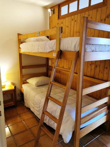 une chambre avec deux lits superposés et une échelle dans l'établissement Résidence Saint Guibert - Appartement au coeur du vieux village MAE-1261, aux Gets