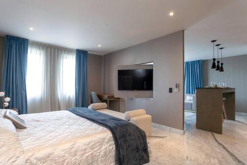 a bedroom with a large bed and a flat screen tv at Close to Beach Nice Suite in Cabo's Downtown - 5 in Cabo San Lucas