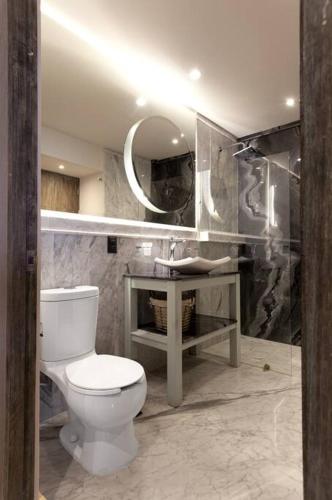 a bathroom with a toilet and a sink and a mirror at Close to Beach Nice Suite in Cabo's Downtown - 5 in Cabo San Lucas