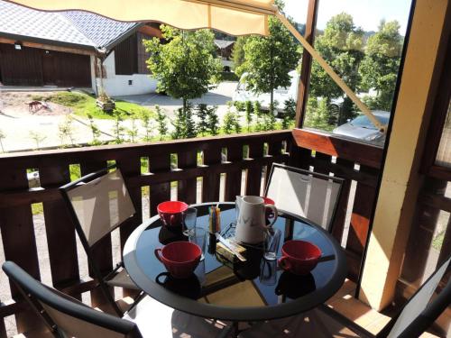 - une table sur un balcon avec des tasses rouges dans l'établissement Résidence Rebiole - Appartement fonctionnel et calme à deux pas du cen MAE-1301, aux Gets