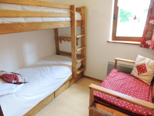 - une chambre avec 2 lits superposés et une chaise dans l'établissement Résidence Rebiole - Appartement fonctionnel et calme à deux pas du cen MAE-1301, aux Gets