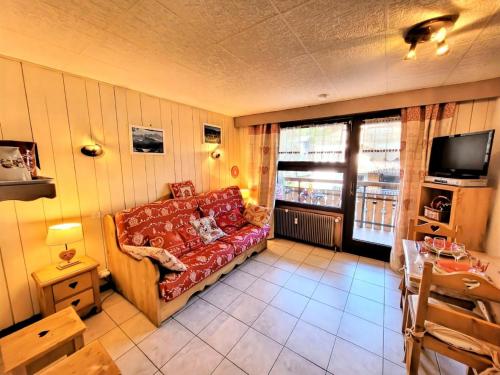 un salon avec un canapé rouge et une télévision dans l'établissement Résidence Ranfolly - Studio au pied des pistes MAE-1351, aux Gets