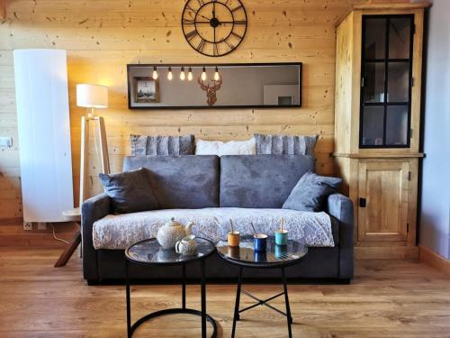 un salon avec un canapé bleu et un réveil dans l'établissement Résidence Plein Soleil B - Studio cabine au calme et proche des pistes MAE-1311, aux Gets