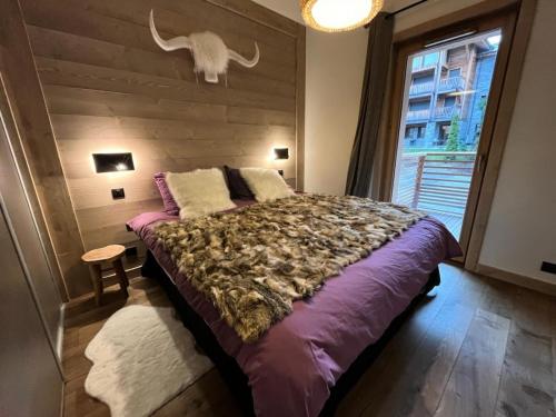 une chambre avec un grand lit et une fenêtre dans l'établissement Résidence Le Stella - Appartement 4 personnes au centre MAE-1331, aux Gets