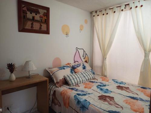 a bedroom with a bed and a window at Hostal CasAlé Usaquén in Bogotá